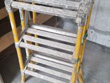 a stack of ladders sitting on the floor in a room