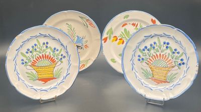 three plates with flowers painted on them sitting on a table