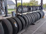 many tires stacked up on a pallet in a garage