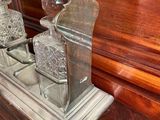 a silver vase on top of a wooden dresser