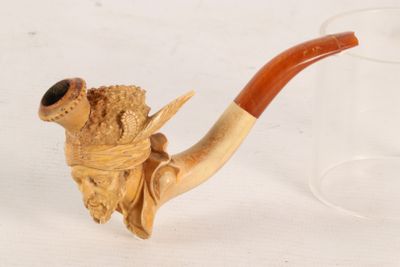 a small pipe with a wooden handle on a table