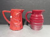 deux vases rouges posés l'un à côté de l'autre sur une table