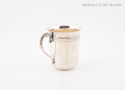 a silver cup with a handle on a white surface
