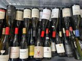 de nombreuses bouteilles de vin rangées dans un panier sur l'étagère