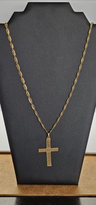 un collier en or avec une croix et une chaîne, posé sur un mannequin