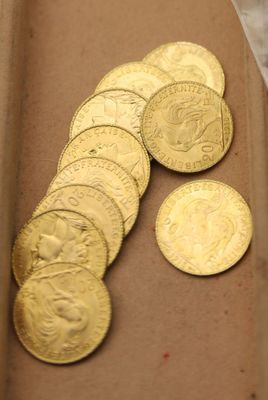 beaucoup de pièces d'or dans une boîte posée sur la table
