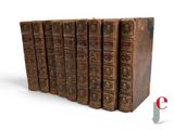 several old books are lined up in a row on a white surface