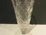 a glass vase sitting on a table with a black background