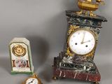 une petite horloge posée à côté d'une autre petite horloge sur une table