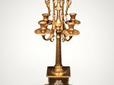 an antique brass candelabra with five candles on a stand