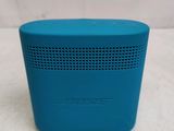 a close up of a blue speaker sitting on top of a table
