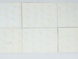 six white cards with yellow writing on them on a white surface