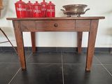 une table en bois sur laquelle sont posées des bouteilles rouges