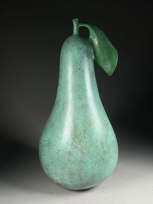a close up of a green pear with a leaf on it