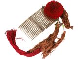 a hair comb with a red pom pom on top of it