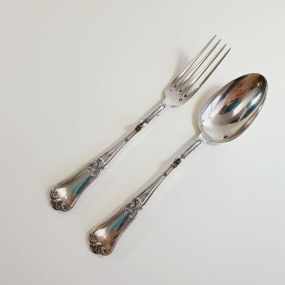 two spoons and a fork on a white table