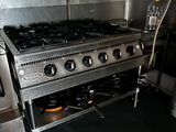 a stainless steel stove in a kitchen with a black floor