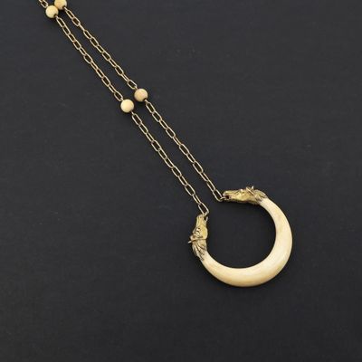 un collier en or orné d'un croissant et de perles sur fond noir