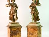 deux statues représentant une femme tenant une harpe et un homme tenant un vase