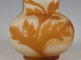 a glass vase with a design of leaves on it
