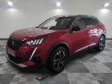 Le SUV rouge est garé sur un sol à damier dans un garage.