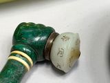 a green pipe that is next to a banana