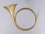 an image of a brass french horn hanging from the ceiling