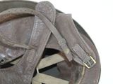 an old baseball helmet with a leather strap on it