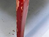 a close up of a red table with peeling paint on it