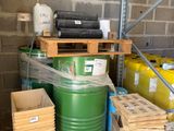 un fût vert posé sur une palette à côté d'une pile de cartons