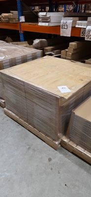 Plusieurs piles de cartons sont empilées les unes sur les autres dans un entrepôt