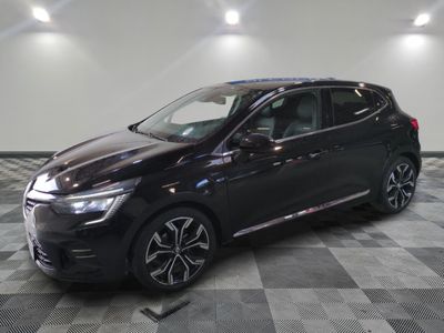 Une voiture noire est garée dans une grande pièce au sol carrelé.