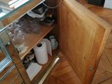 a small cabinet with a door open on a hard wood floor