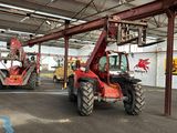deux tracteurs rouges garés à l'intérieur d'un grand bâtiment