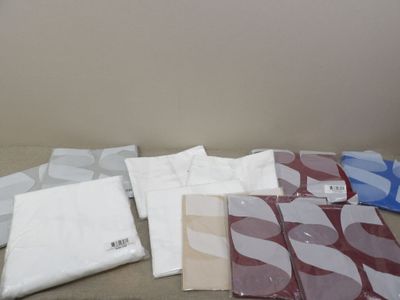 a lot of different types of bed sheets on the bed