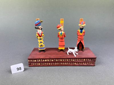 two figurines of three people and a dog on a table