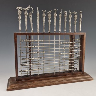 a metal sculpture of a group of people on a wooden stand