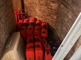 several red suitcases are lined up in a narrow room