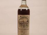 une vieille bouteille de whisky posée sur une surface blanche
