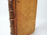 an old book sitting on top of a white table next to a white wall