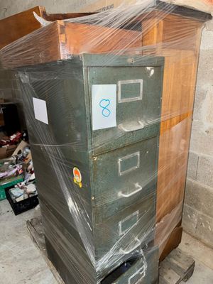 une pile de classeurs emballés dans du plastique dans une pièce