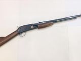 a shotgun with a wooden handle on a white surface