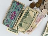 a pile of money sitting on top of a table next to coins