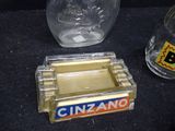 a glass bottle and a glass ashtray sitting on a table