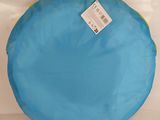 a blue and yellow round pillow with a tag on it
