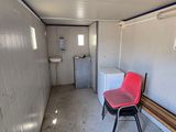 a red chair sitting in a room with a white wall