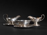 a pair of silver plated saucers and saucers on a black background