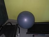 un ballon d'exercice, un tapis de course et un écran posé par terre
