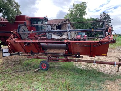 un gros tracteur rouge attelé à une remorque