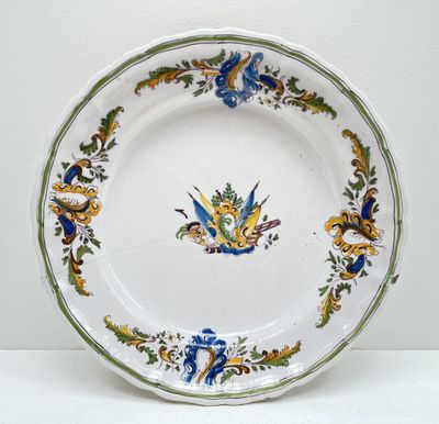 une assiette blanche ornée d'un motif bleu et jaune